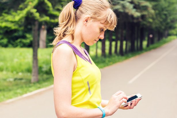 Person using a fitness app on their smartphone, raising concerns about privacy and data security.