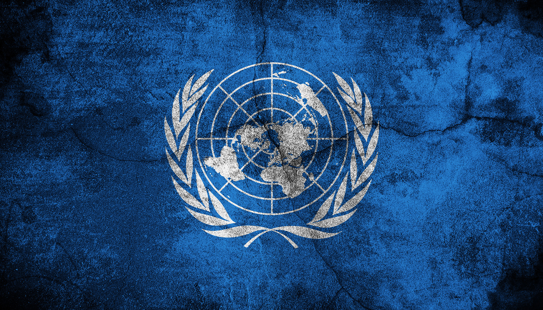 The UN logo on a cracked blue surface, representing global governance and challenges in cybercrime policies.